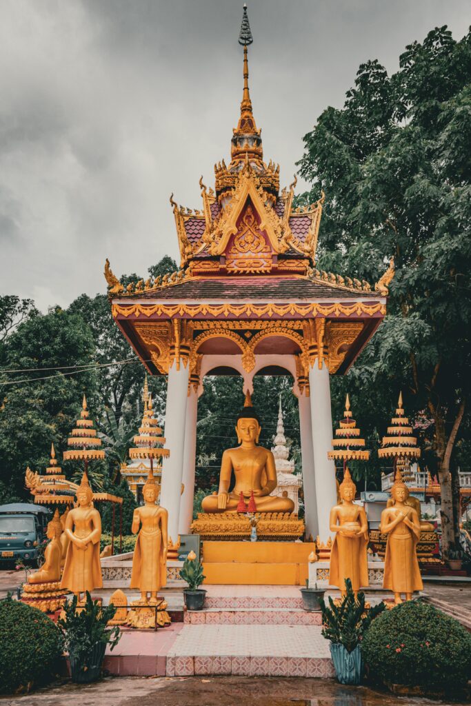 Ornate golden Buddha statues at a temple in Vientiane, Laos, symbolizing spirituality.